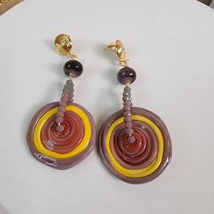 Flamework beads in disk shape hanging form a wire filled with crystals, all attached to a gold plated earring stud.