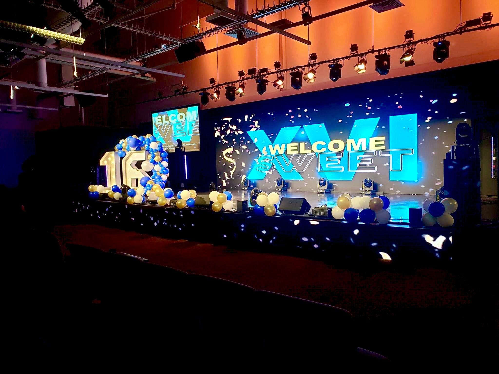 Stage with “18” balloons and “XXI! Welcome” text. Employee fun days