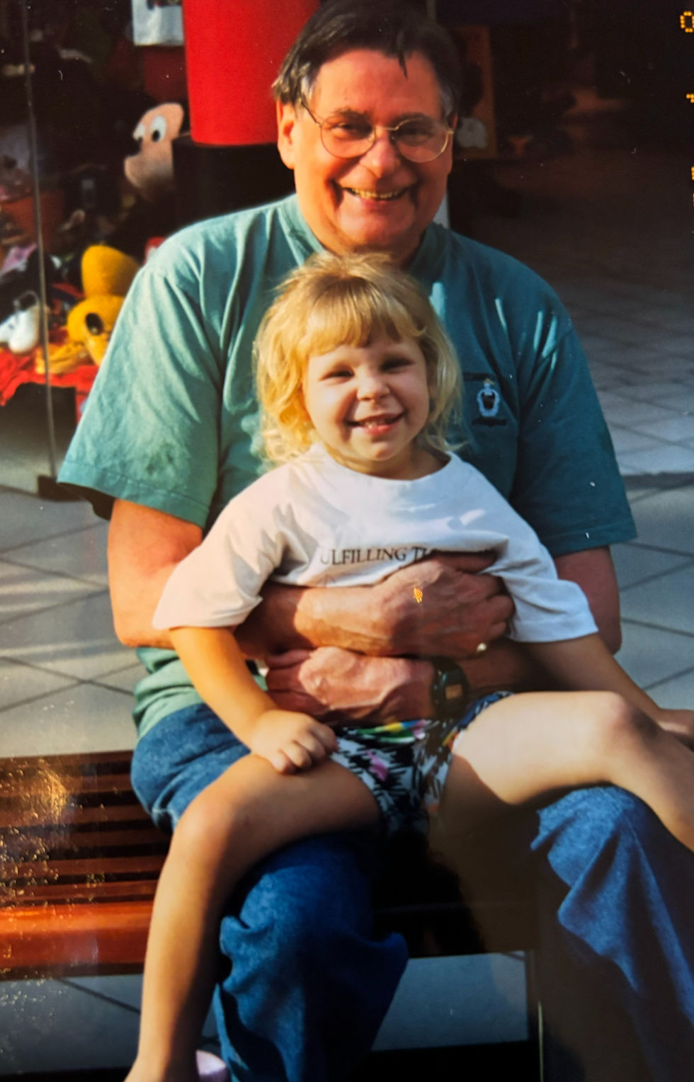 A grandfather holding his granddaughter on his lap.