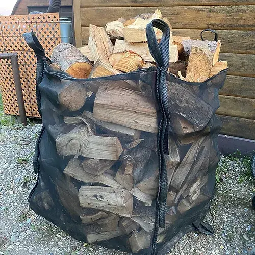 Thumbnail: Black mesh bag filled with firewood; Little Lumberjacks Firewood for sale.