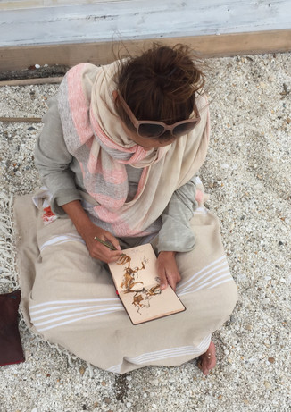 Die Künstlerin Chantal Hediger skizziert am Strand in Sardinien.