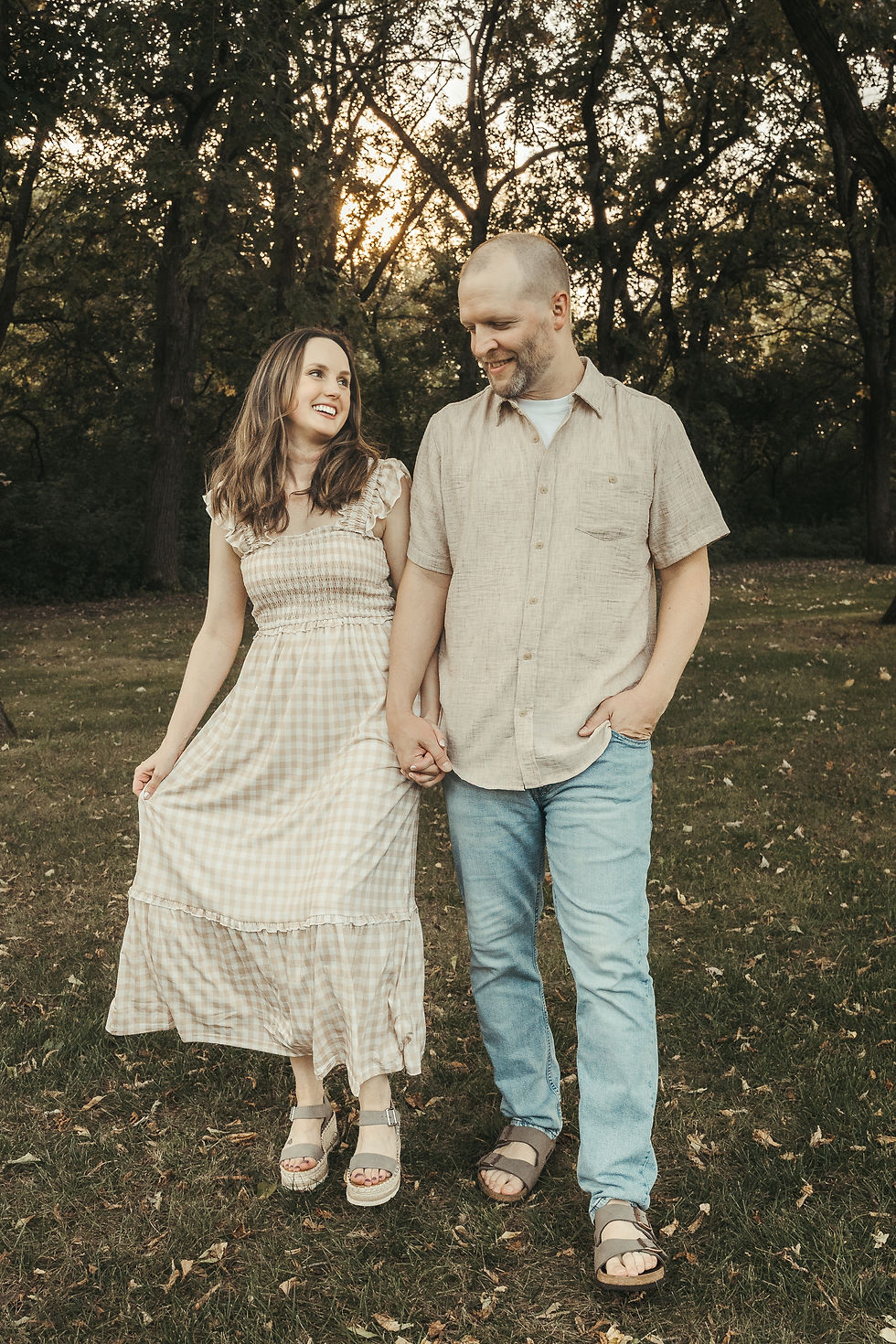 Mom and dad walking hand-in-hand through the park.