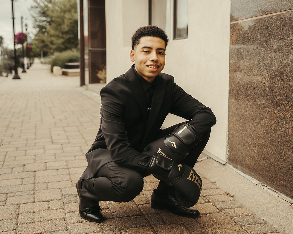 Boxing-themed senior portraits in Monticello MN with gloves and his suit.