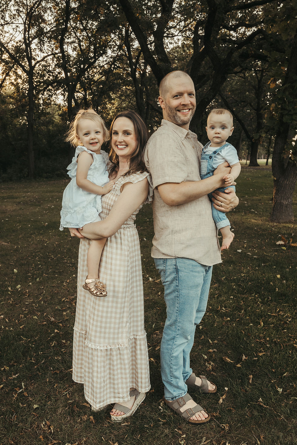 Family of four smiling at the camera in Monticello park