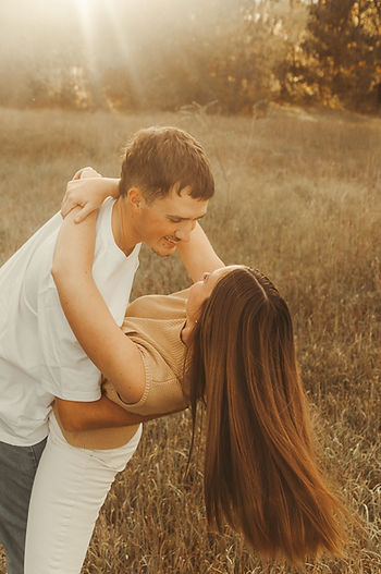 Couples photos captured in Monticello, Minnesota. Couple dancing in a field with the sunset behind them.