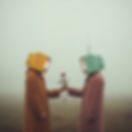 Two people with retro TV heads exchange a red rose, symbolizing love and technology.