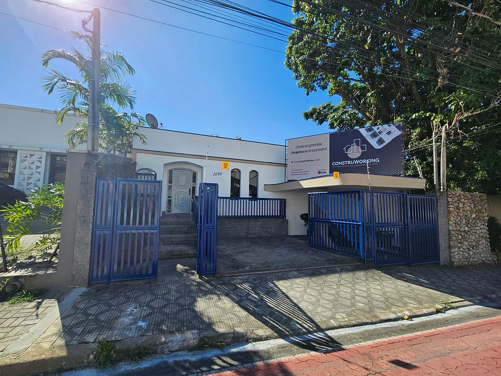 Fachada do coworking Taubaté com portão azul e placa informativa.