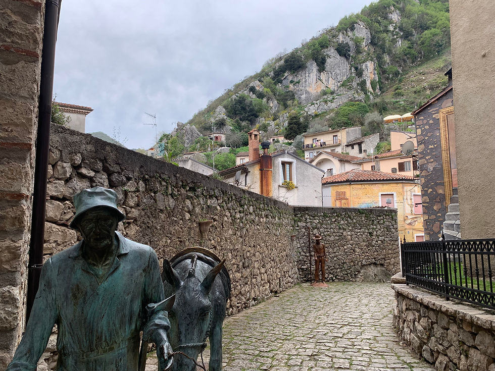 statua con un uomo che porta a spasso il suo asilo per le vie di sant'angelo le fratte