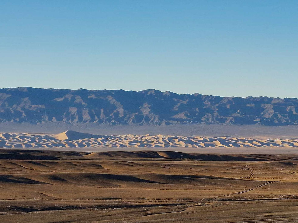 A flat gravel desert plain stretching to a distant mountain range