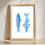 Thumbnail: Watercolor painting of two blue fish in a framed artwork on white background.