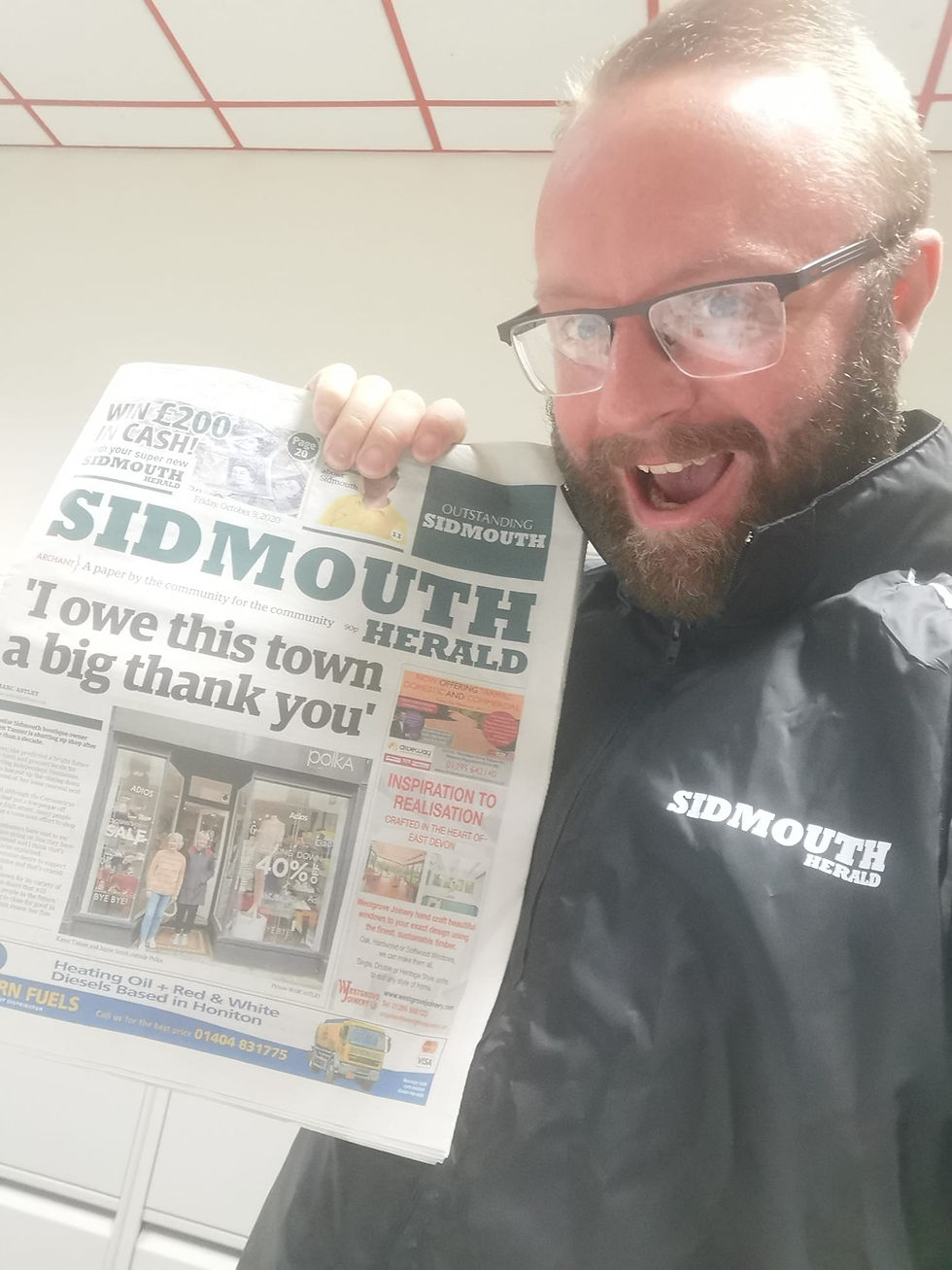 Man holding a newspaper to the camera