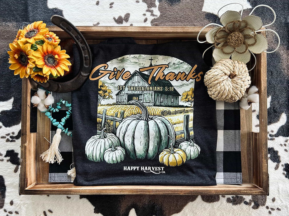 A graphic tee with rustic pumpkins followed by the words "Give Thanks," inspired by the Bible verse 1 Thessalonians 5:18.