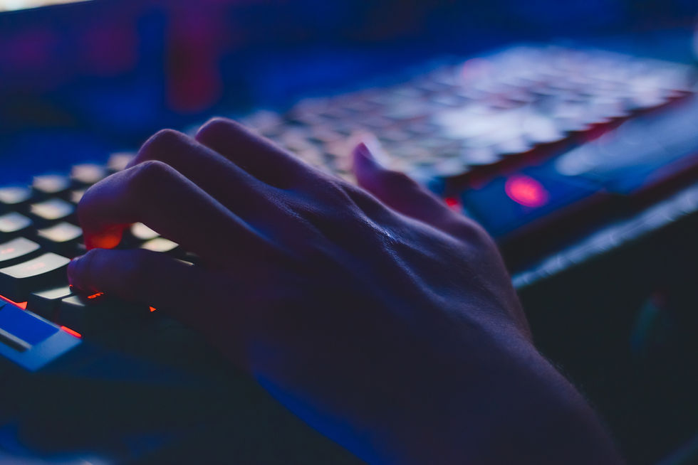 Keyboard in the dark with a hand typing.