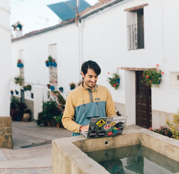 Rooral participant working remotely with his computer from an outdoor fountain in Benarraba, Malaga.