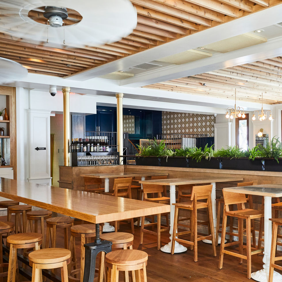 Custom restaurant interior at Wildseed with wood tables, millwork and exposed ceiling