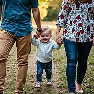 parents holding hands with a toddler between them.jpg