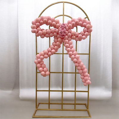 Pink bow balloon garland on gold backdrop by Party and Co. Event Styling in the GTA