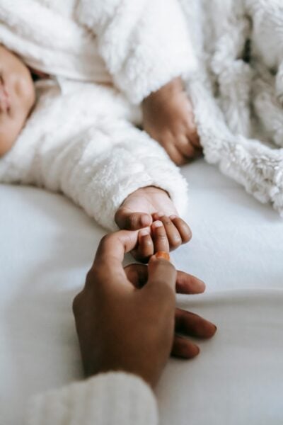 Mom Holding Baby's Hand | The Peaceful Sleeper