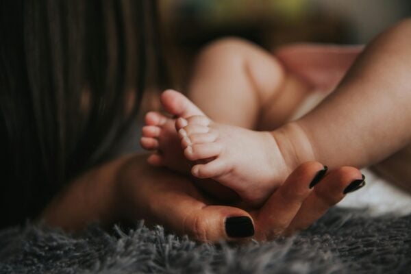 Mom Holding Baby Foot | The Peaceful Sleeper