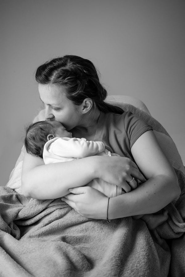 woman rocking baby to sleep in her arms | The Peaceful Sleeper