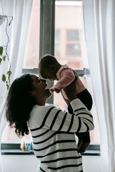 Mom Holding Baby by Window | The Peaceful Sleeper