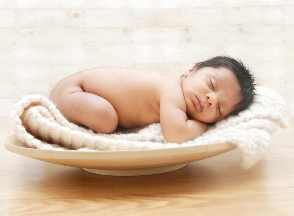 Baby sleeping on a towel in a bowl, resting peacefully and calmly using attachment based sleep training. Find a sleep trainer who has the traits you want, with guidance from The Peaceful Sleeper.