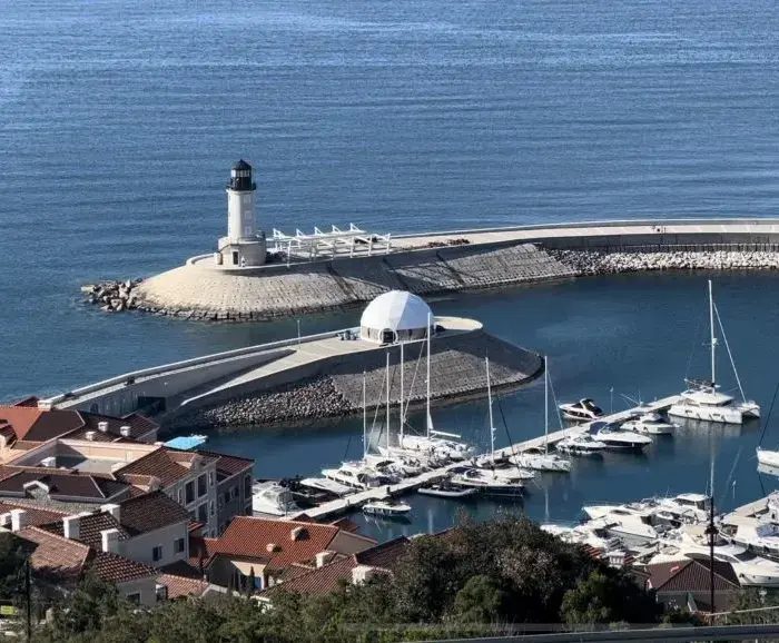 un grand dôme géodésique sur une digue de marina avec vue sur la mer
