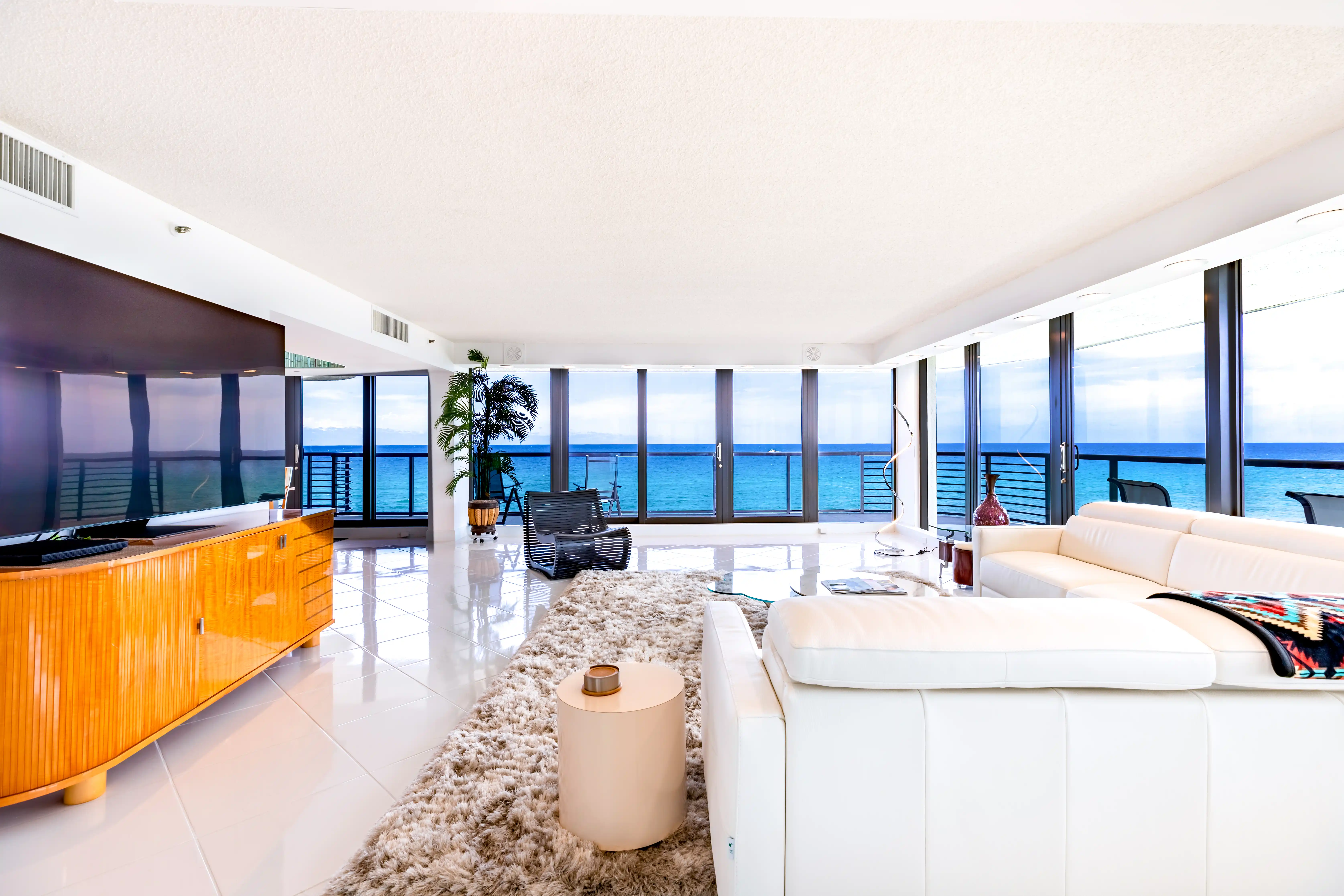 Real estate photography of a modern and bright living room in a Delray Beach condo, The view is of the ocean. The ro