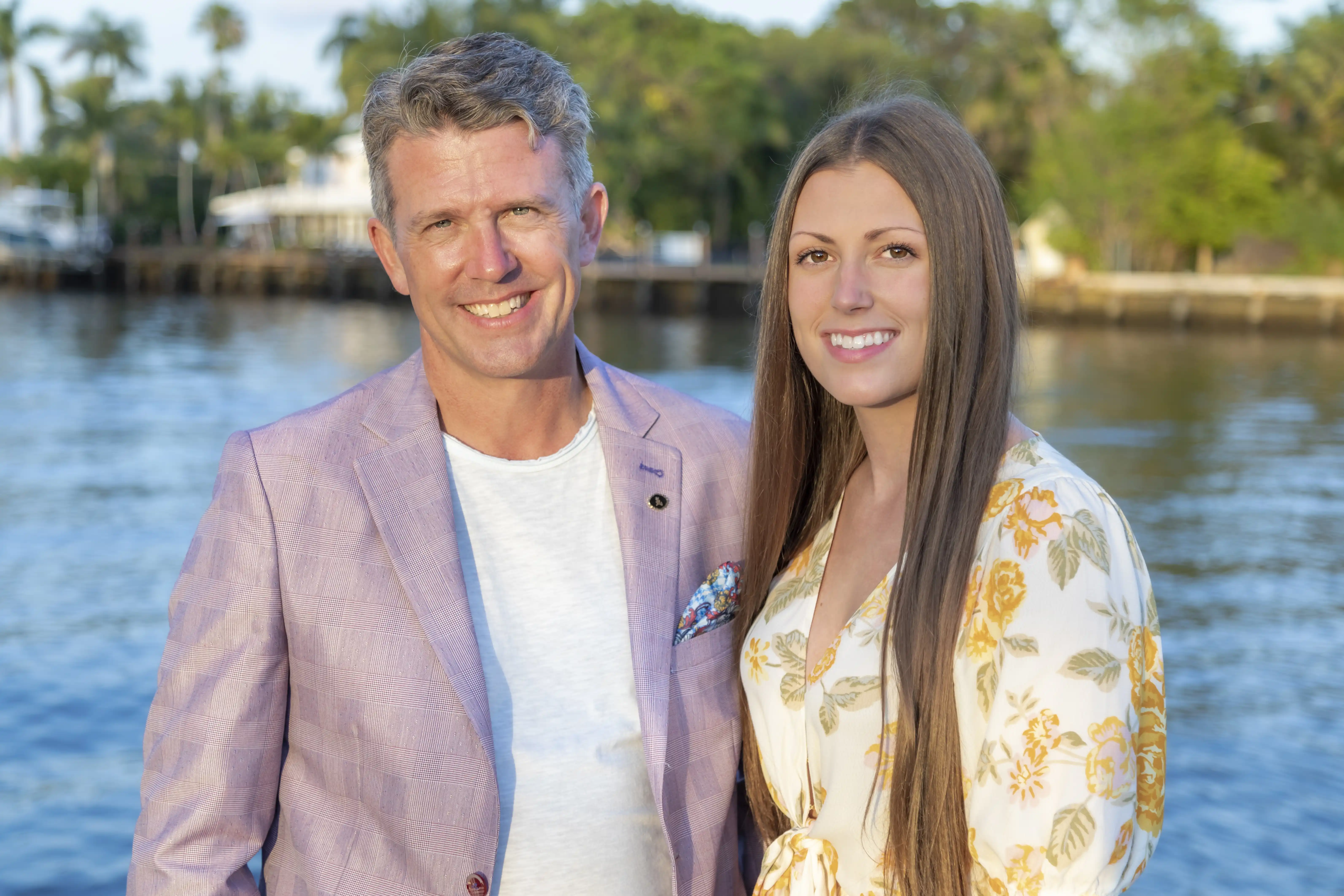 a professional portrait of a father and daughter in delray beach florida. They are posing against the water