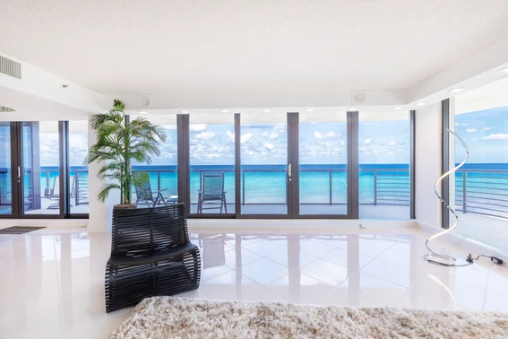 A modern bright white living room with a panoramic view of the blue ocean on the beach in Delray