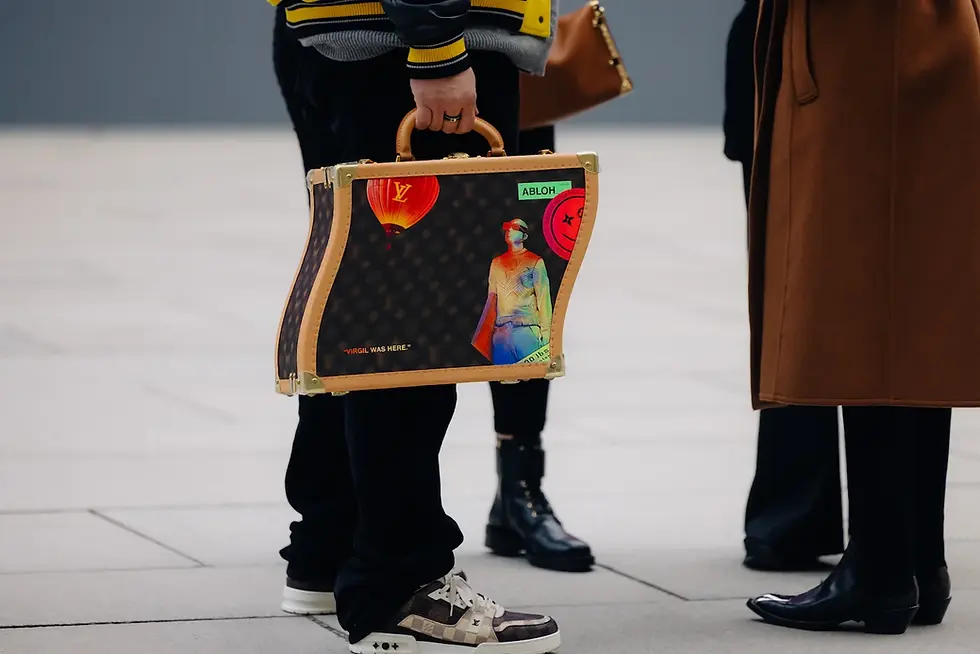 Person carrying a wavy Louis Vuitton briefcase with colorful art.