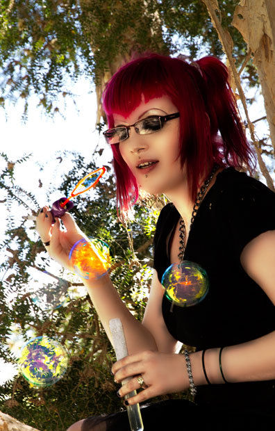 Girl blows bubbles in tree