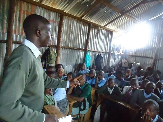crowded Kenya school room with volunteer teacher metal walls volunteer work school kids jobs Kenya slums Nairobi