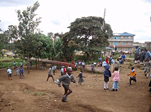 impoverished children playing on dirt playground Kenyan slum at volunteer school