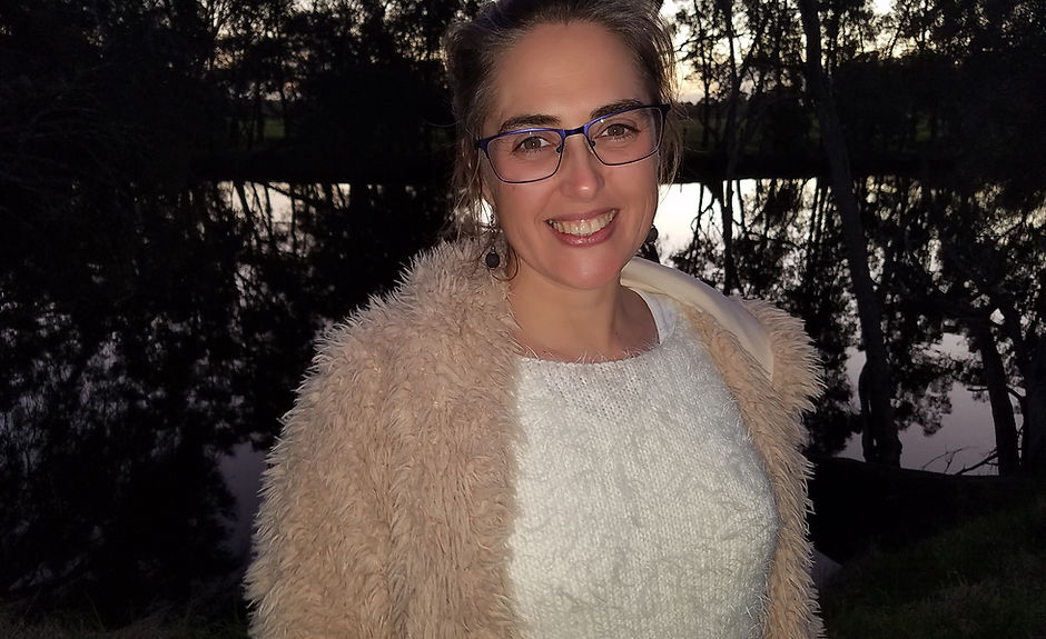 Picture of Stormie in nature at dusk with radiant smile and kind sparkling eyes