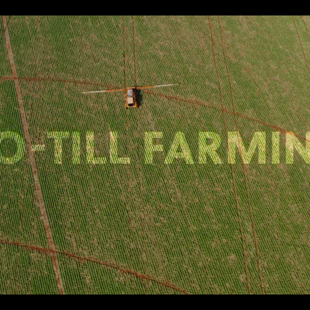 Aerial view of farmland in Brazil with agricultural machinery, representing large-scale crop