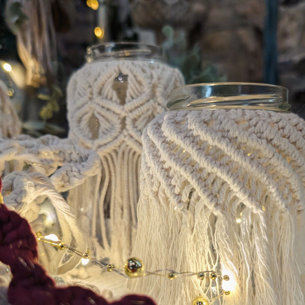 A group of three macrame-covered jam jars with electric tea lights