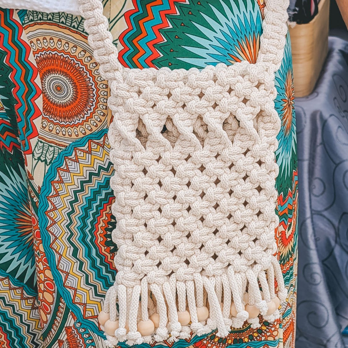 A neutral-coloured macrame handbag made with chunky 9mm cord and dark brown handles. There's a pair of sunglasses and a small succulent in a little hexagonal cement pot in the foreground.
