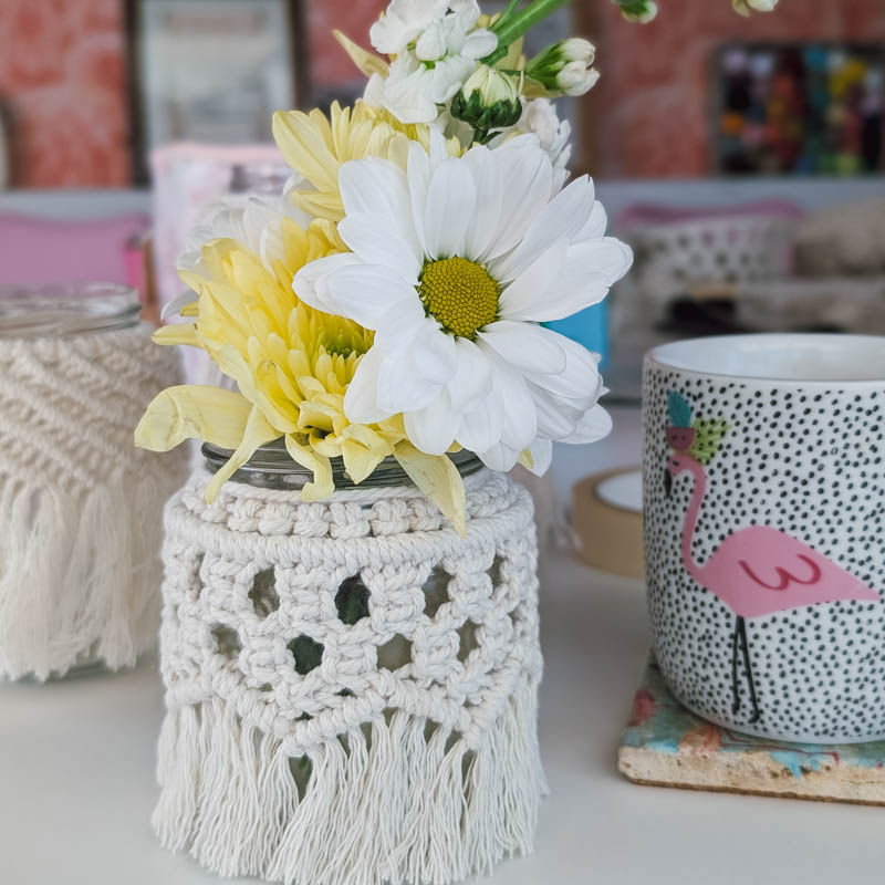 A group of three macrame-covered jam jars with electric tea lights