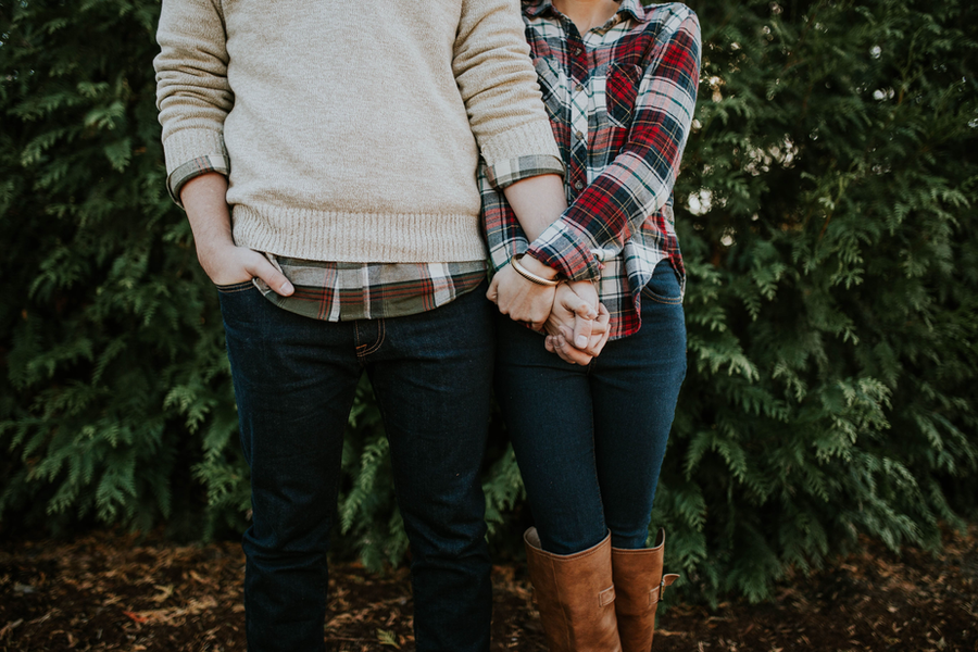 Casal heterosexual de mãos dadas em um cecnário de plantas