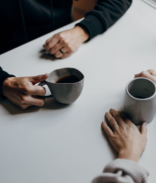 Mãos e xícaras, pessoas tomando café ou chá em uma mesa