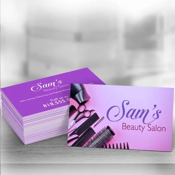 A stack of purple silk business cards with a geometric pattern and the text 'Sam's Beauty Salon'.
