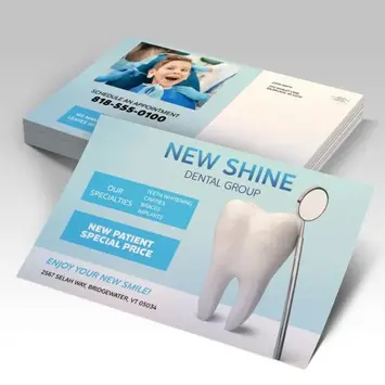 Stack of silky-laminated postcards featuring a clean dental-clinic design and mailing panel