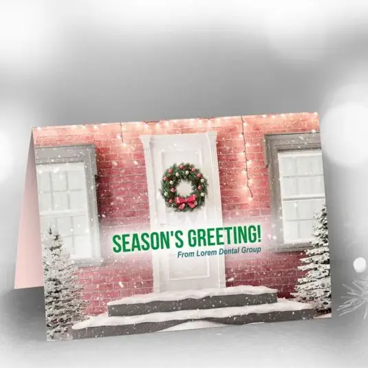 olded greeting card with snowy house illustration and “Season’s Greetings” text