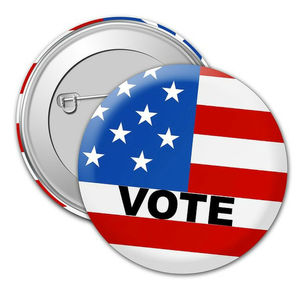 A round button with an American flag design and the word 'VOTE' printed in white.