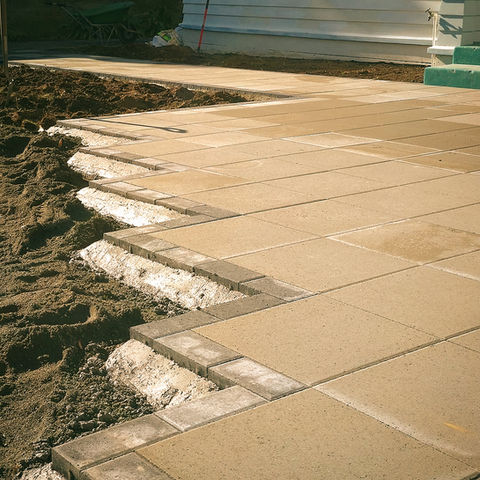 Construction of a paved patio with brick edging.
