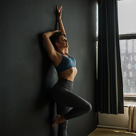 A fitness coach making a pose by the wall.