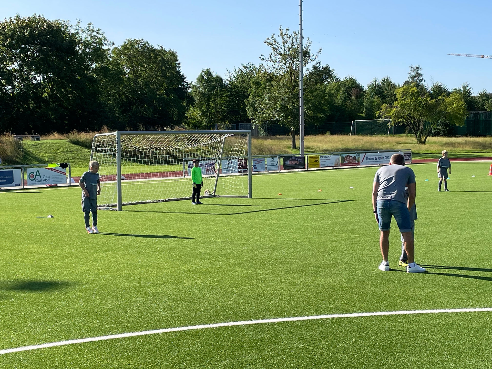 Kinder und Trainer der SG Eifelland auf einem Fußballplatz.