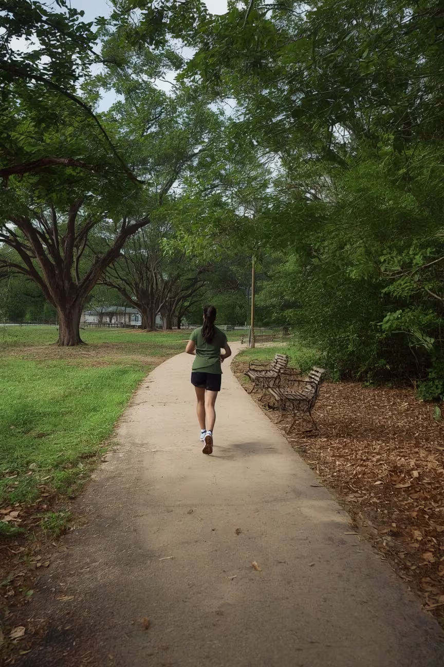 A Photo of a Runner on a concrete Paved path at Dennis Johnston Park. 