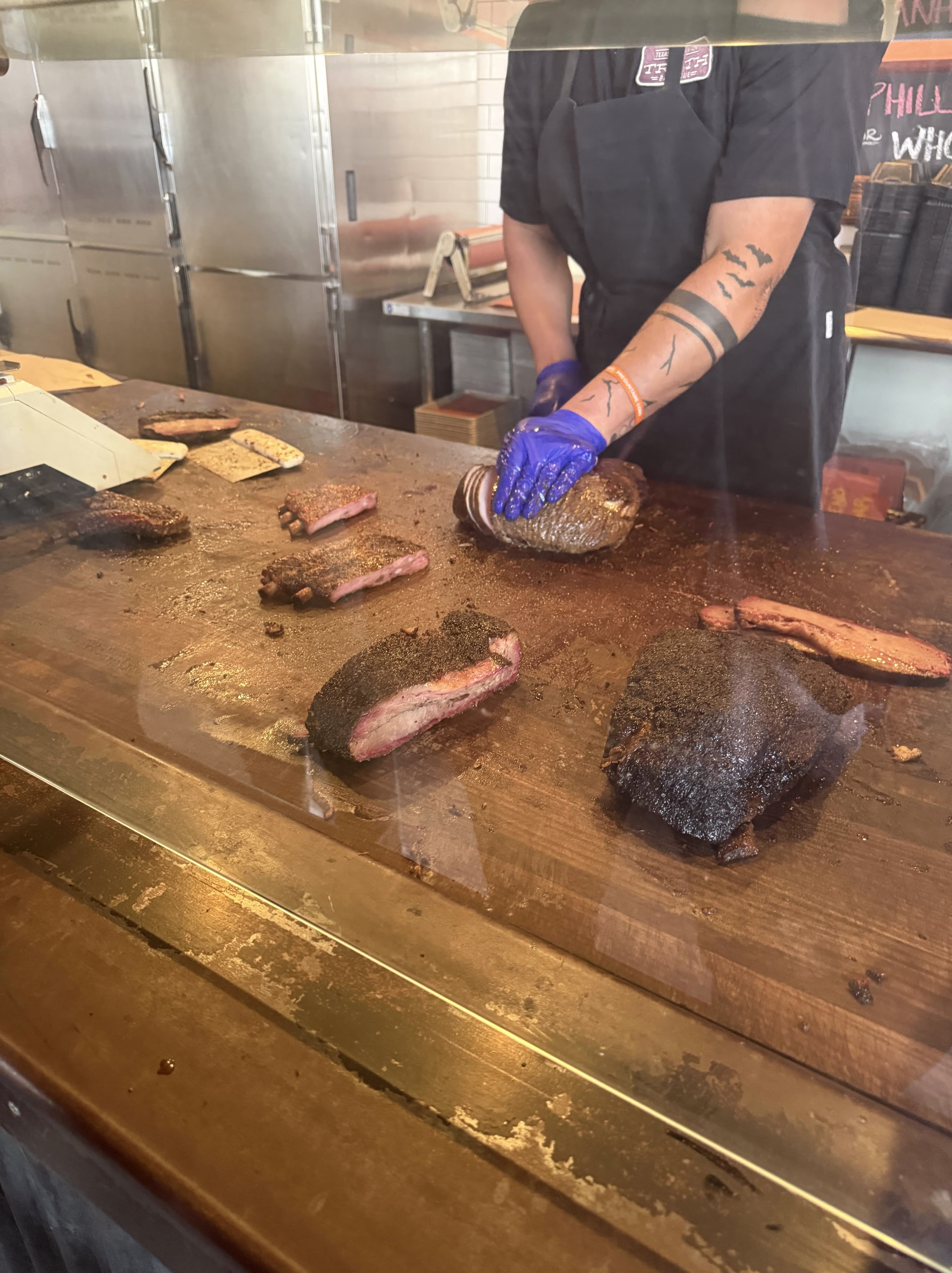 A Photo Of The Freshly Cooked Brisket being Cut by the employee at Truth BBQ